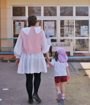 手を繋いで歩く子どもと先生